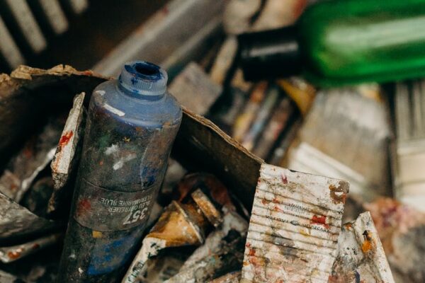 A creative mess of used paint tubes and plastic bottles, capturing an artistic chaos.