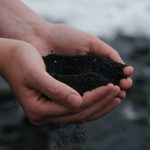 person holding black soil