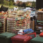 Stacks of carton boxes and bins in an outdoor storage area, exemplifying waste management.