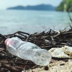 Discarded plastic bottle on a Malaysian beach, highlighting environmental pollution.
