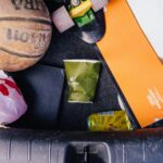 Close-up of basketball, papers, and trash in a car trunk, illustrating untidiness.