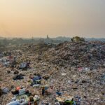 Aerial shot of a large landfill with garbage piles, showcasing waste management challenges.
