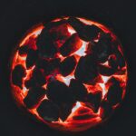 A mesmerizing view of glowing charcoal embers with intense fiery glow and deep contrast.
