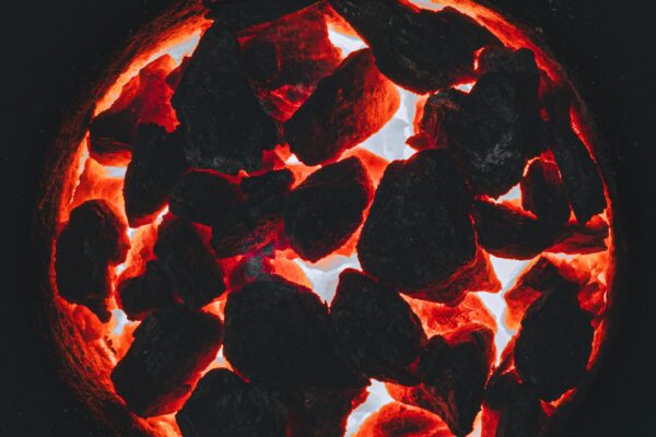 A mesmerizing view of glowing charcoal embers with intense fiery glow and deep contrast.