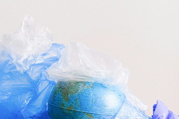A globe surrounded by plastic bags, highlighting environmental pollution.