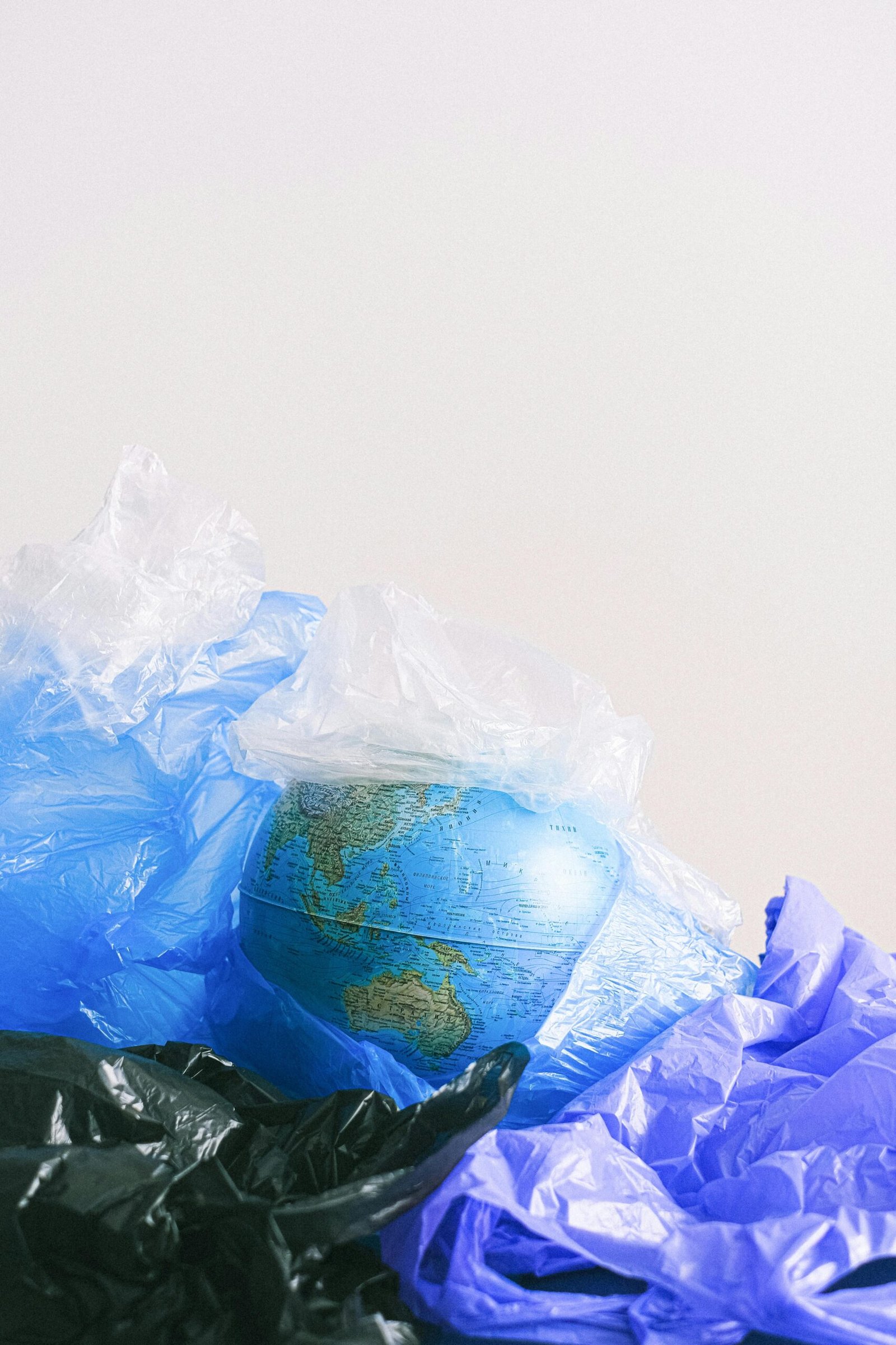 A globe surrounded by plastic bags, highlighting environmental pollution.