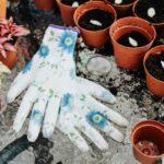 Floral gloves and potted plants on a table, perfect for home gardening inspiration.
