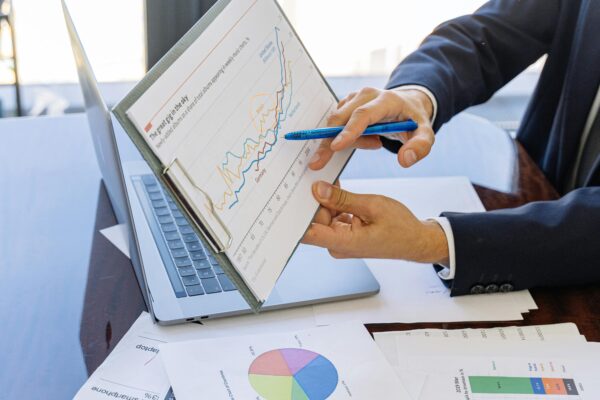 Business professionals discussing financial graphs and charts in an office setting.
