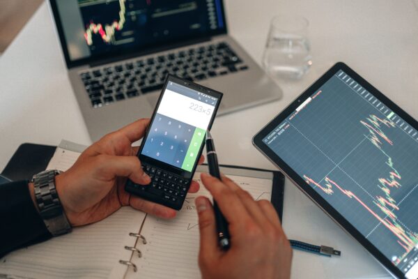 A workspace with devices, charts, and a calculator used for trading analysis.