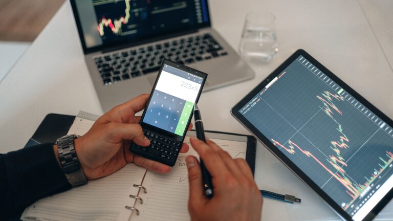 A workspace with devices, charts, and a calculator used for trading analysis.