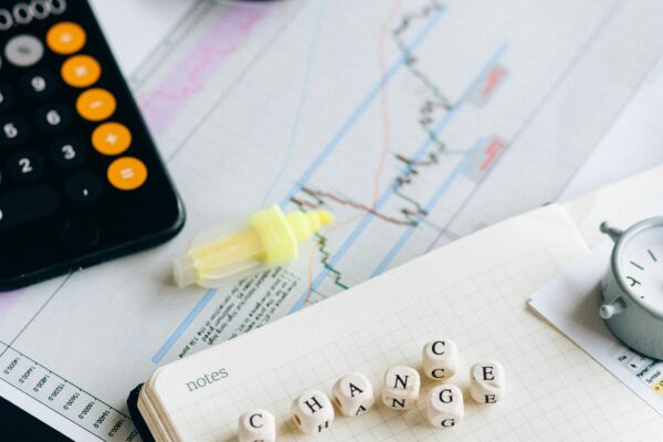 Close-up of financial tools and letter blocks spelling 'CHANGE'.