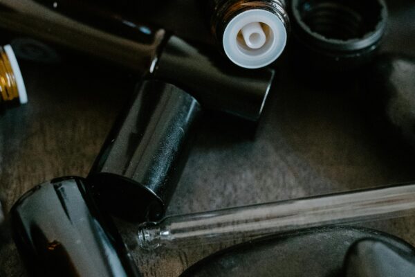 Close-up of essential oil bottles and smooth stones for aromatherapy.