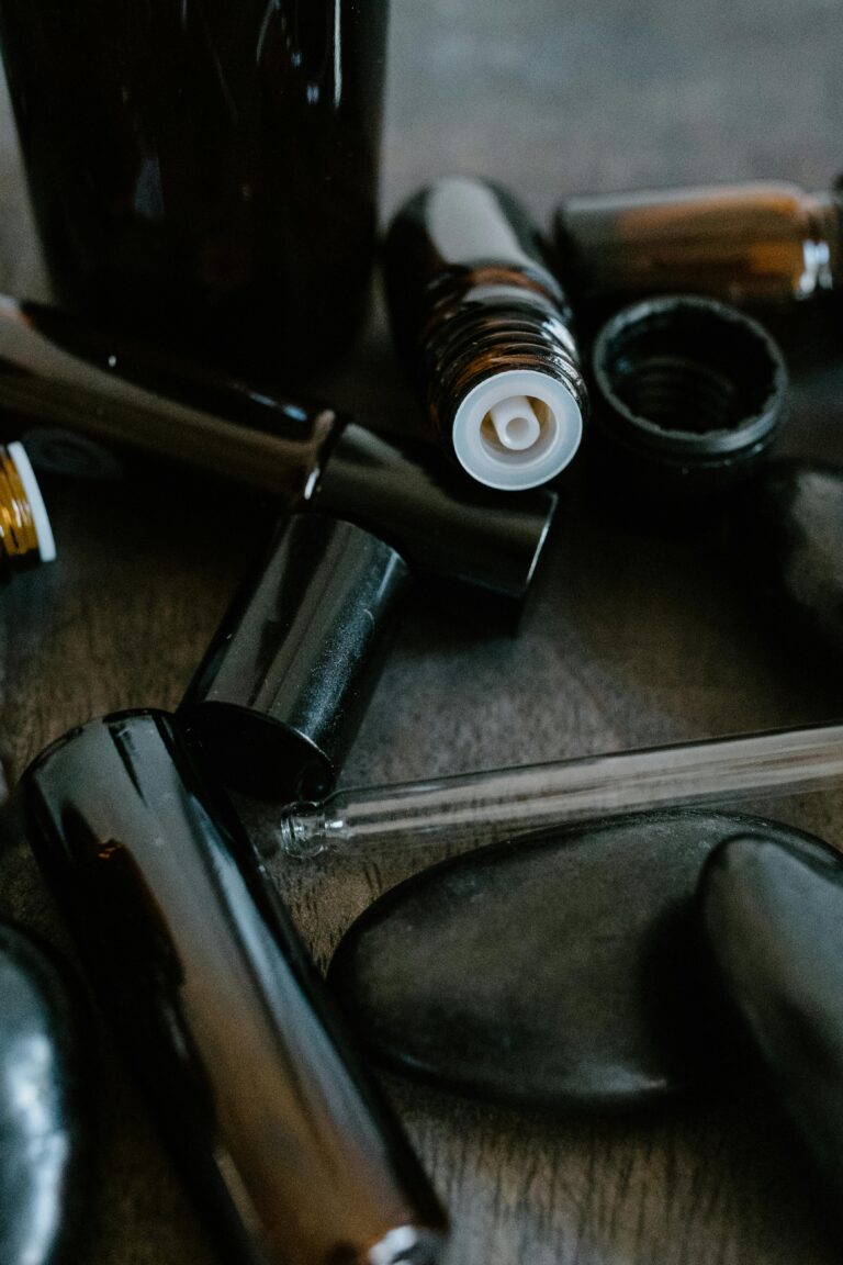 Close-up of essential oil bottles and smooth stones for aromatherapy.