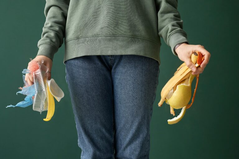 An adult holding organic waste and plastic, highlighting recycling and sustainability.