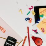 Flat lay of tax documents, receipts, calculator, and colorful numbers for budgeting.