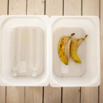 Empty plastic bottles and banana peels sorted in containers for recycling and composting.