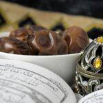 Close-up of a bowl of dates next to an ornate Quran for Ramadan celebrations, featuring intricate patterns.