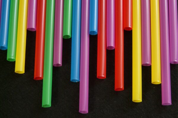 Multicolored plastic straws arranged in a vibrant, artistic pattern.
